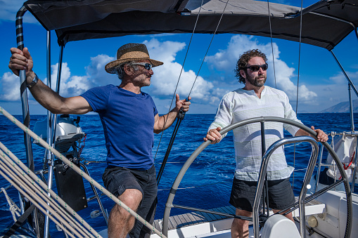 Two adults using a sailboat in the Aegean Sea.