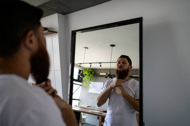 istock Man looking in the mirror at his beard 1441432517
