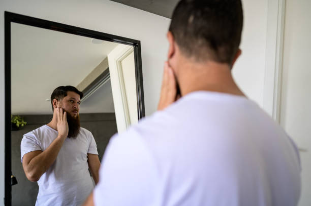 istock Man looking in the mirror at his beard 1441432535