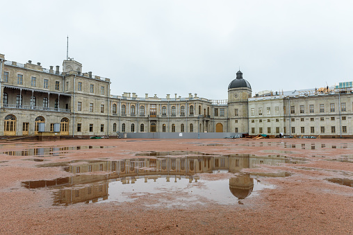 Russia, Gatchina, October 29, 2022: Rainy day. Gatchina Palace and its reflection in puddles