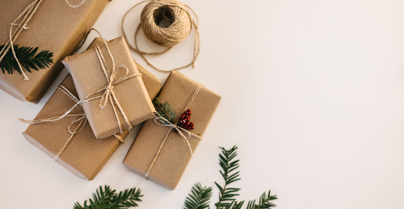 High-angle view of a Christmas presents sustainably wrapped and decorated with pine twigs. Wrapping ideas. Getting ready for Christmas Eve