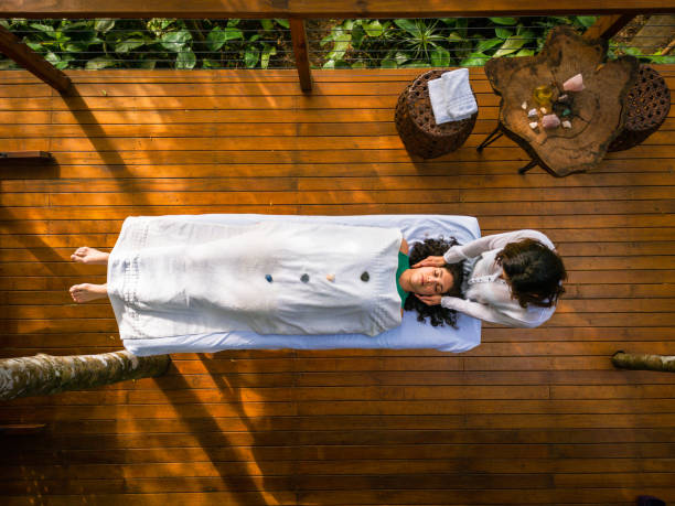 therapist doing reiki on patient - reiki-fotos stockfoto's en -beelden