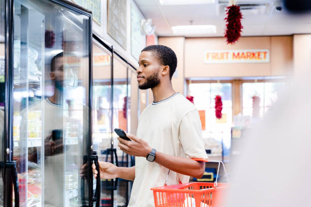 istock Young man opens refrigerator at local market 1441434262