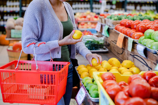 istock Unrecognizable woman with shopping basket selects lemons 1441434312