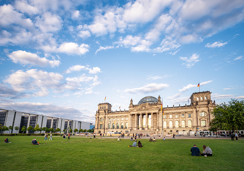 Berlin, Germany – May 14, 2021: A beautiful shot of the tourists in front of the Bundestag (Reichstag) in Berlin against blue cloudy sky on a beautiful sunny day, Germany
