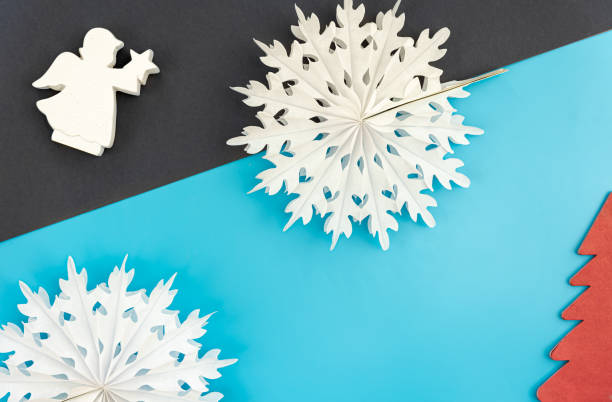 istock Volumetric paper snowflakes on a colored background, flat lay. 1441436272