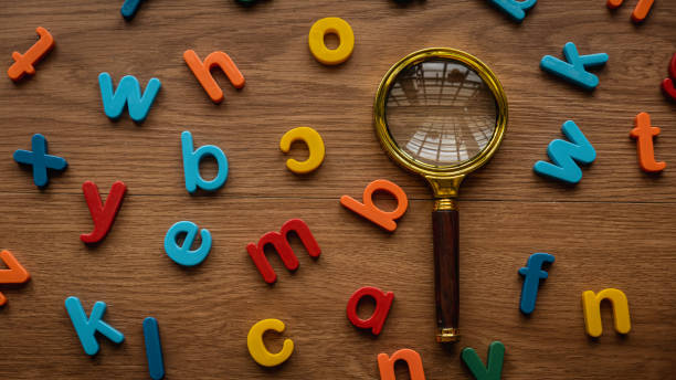 Scattered colorful alphabet with a magnifying glasses. Learning and education concept. Finding keywords. Language learning. stock photo