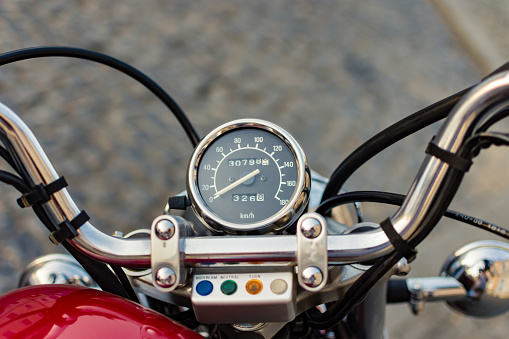 Close up to a motorcycle gauge on the handle bar