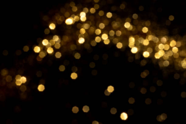 istock Golden blurred bokeh lights on black background 1441439608