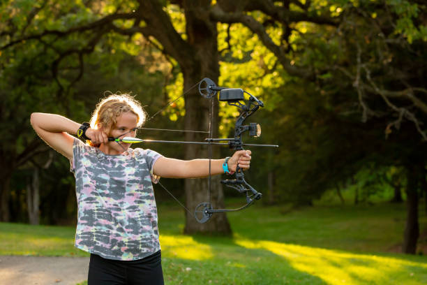 istock Girl At Outdoor Archery Range Practicing Shooting Bow & Arrow 1441440467