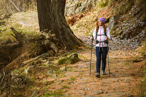 Beautiful young woman hiking in the Italian Alps in autumn