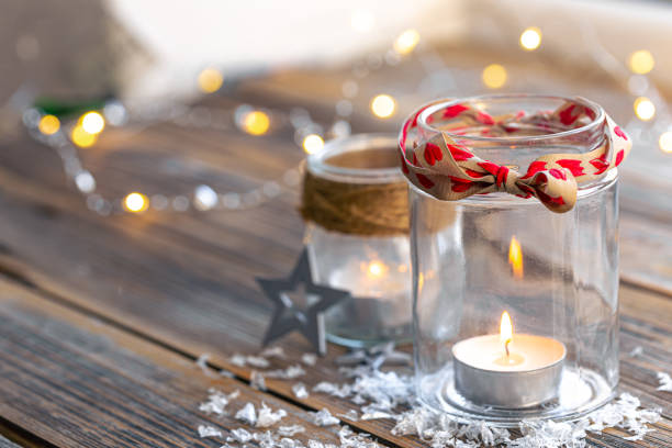 istock Christmas composition with candles in glass jars on a blurred background. 1441444202