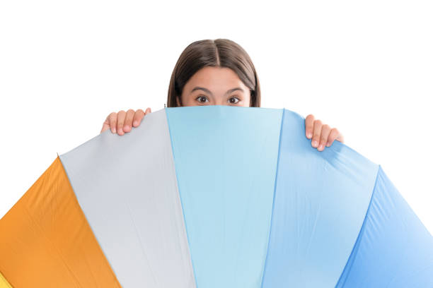 kid hiding behind multicolored rain protection parasol isolated on white background, weather forecast.