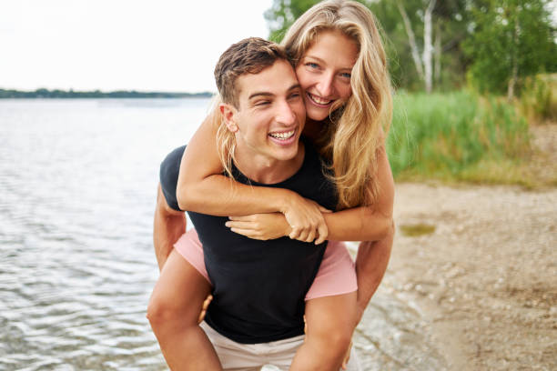 istock a young man piggybacks his girlfriend 1441444437