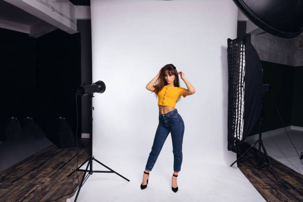 istock girl posing in studio on a white background. camera and tripod f 1441448247