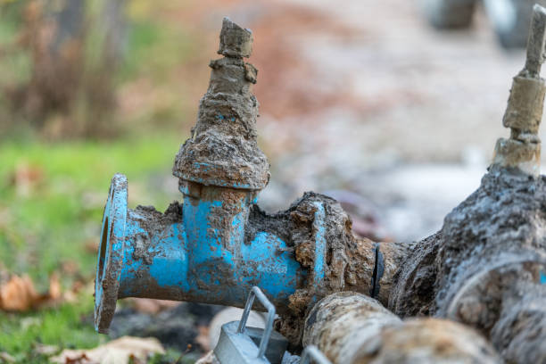 Defekte alte Wasserrohre und Armaturen bei Baustelle am Straßenrand