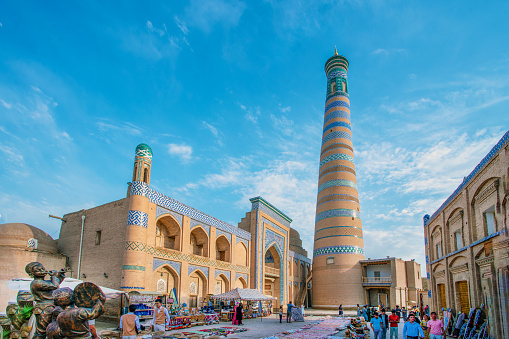 05-11-2022  Khiva Uzbekistan. Idyllic view on  Islam-Khoja minaret and cafe waiters and just walking Uzbeks  in Khiva old city