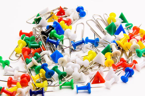 set of pins, color paper clips on a white background, close up view