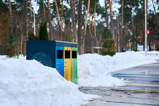 istock Garbage separate containers for plastic, paper and glass in a winter park on the path 1441459896