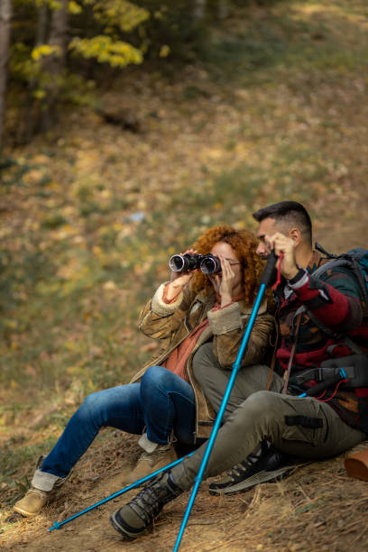 istock Young woman using binoculars in the woods 1441465592
