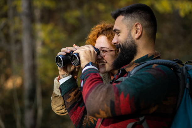 istock Lovely young couple in the woods using binoculars 1441465640