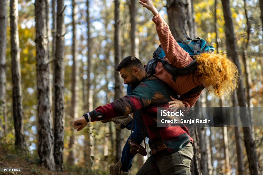 Junger Mann trägt seine Freundin durch den Wald - Lizenzfrei Abenteuer Stock-Foto
