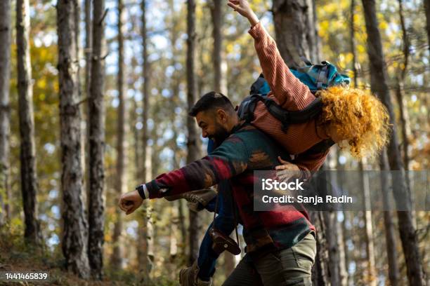 Junger Mann Trägt Seine Freundin Durch Den Wald Stockfoto und mehr Bilder von Abenteuer - Abenteuer, Autoreise, Baum