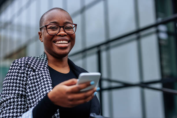 istock Cheerful woman with smartphone outside. 1441467236