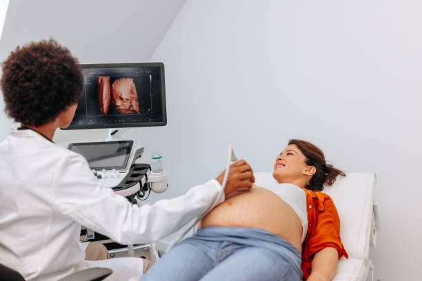 Doctor showing patient baby on ultrasound. stock photo