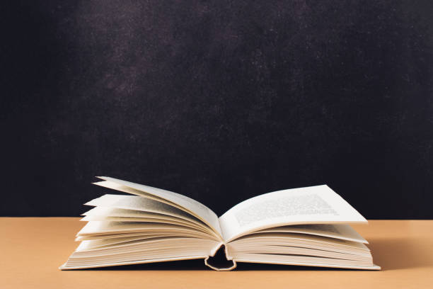 istock Minimal reading concept made with open book on textured black and brown background. Retro aesthetic. 1441474275