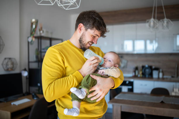 istock Happy dad feeding baby boy. 1441476223