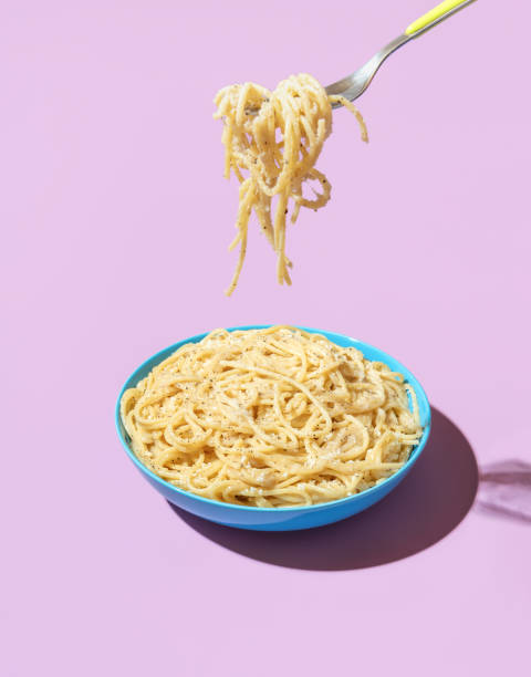 istock Eating pasta with a fork, minimalist on a purple background 1441479472