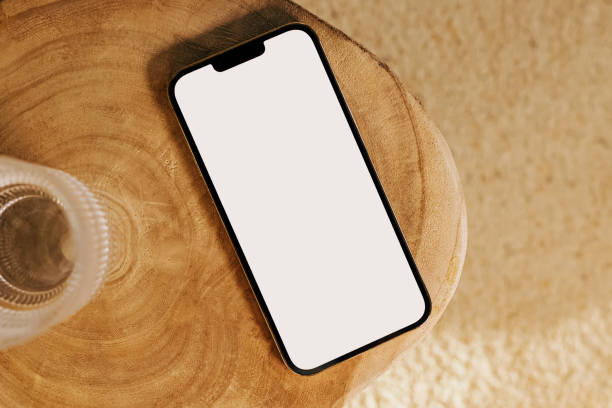 istock Modern smart phone mock-up, mobile phone with white empty screen on the wooden table 1441481350