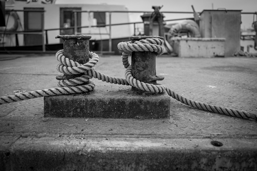 thick rope is wound on a bollard in the harbor