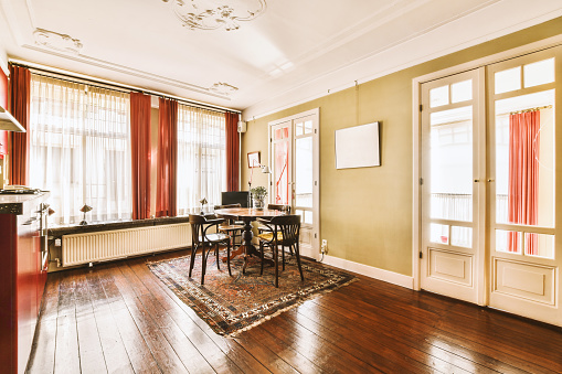 A dining area with a small table located on a carpet against the wall in a cozy house