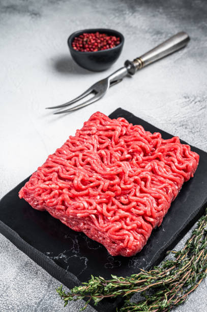 istock Raw mince Minced beef, ground meat with thyme and pepper. White background. Top view 1441486303