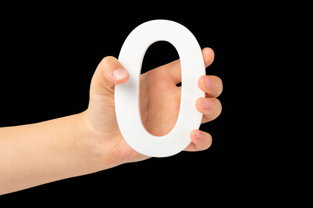 istock Zero in hand. The number zero is clasped in a hand isolated on a black background. Number zero white in a child's hand on a black background. 1441487127