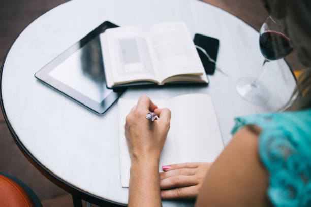 istock Cropped image of female student writing memo notes in textbook during information learning from literature book, selective focus on education equipment for exam preparation at table desktop 1441487219