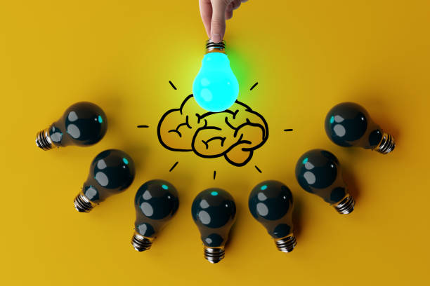 istock A hand holds a lit light bulb against the background of other extinguished light bulbs and a sketch of the brain. 1441490155
