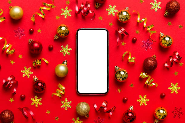istock Christmas online shopping from home phone with blank white display top view. smart mobile with copy space on colored background with Christmas decorations balls,. Winter holidays sales background 1441490698