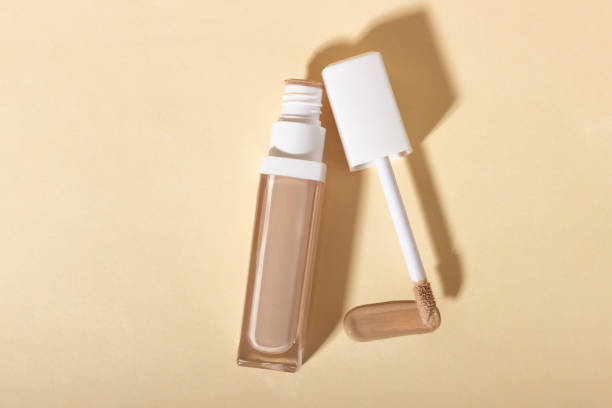 istock Concealer cream on a background with shadows. Face corrector on beige background with copy space. Blank mockup for product 1441491861