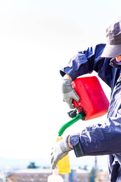 istock Man Pouring Engine Oil into Plastic Gasoline Can Preparing the Perfect Mixture 1441495500