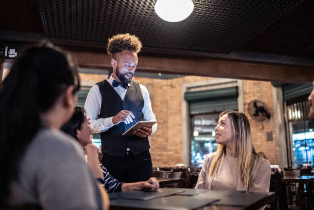 istock Waiter taking orders from costumers at a bar 1441499826