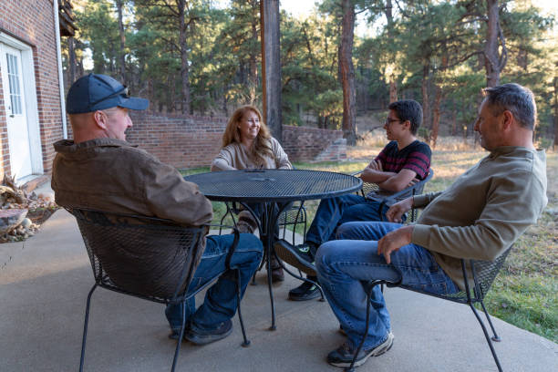 istock Four people at a backyard patio table having a discussion 1441501224