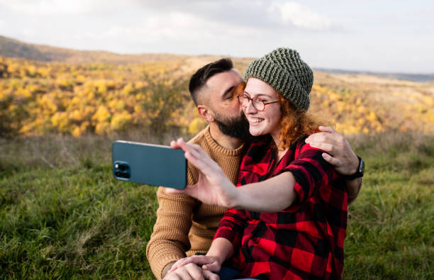 istock Man kissing his girlfriend while she is taking a selfie 1441502023