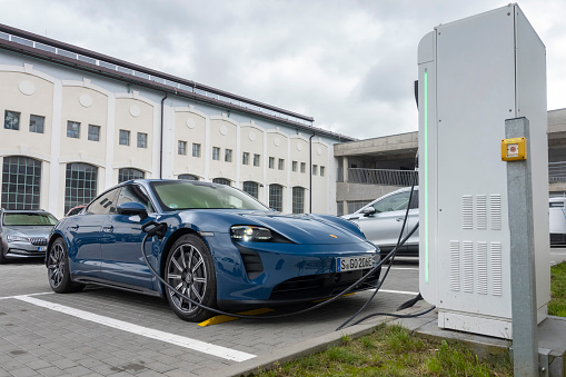 Prague, Czech Republic - 31 August, 2021: Porsche Taycan on public electric charging station. Electric cars replaces the classic fuel vehicles in future.