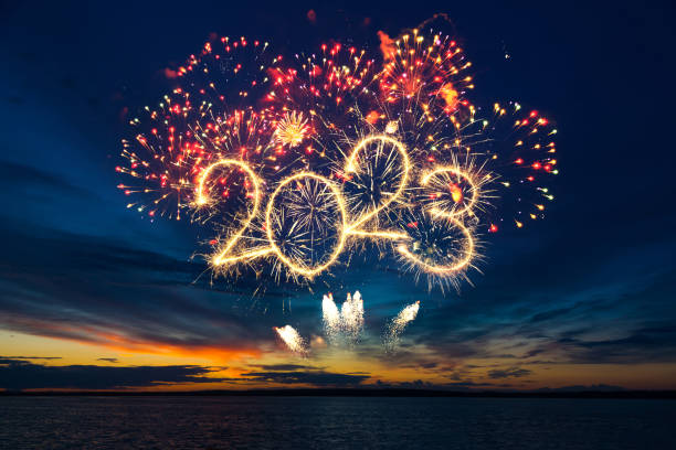 Happy New Year 2023. Happy New Year 2023. Beautiful creative holiday web banner or flyer with red fireworks and Golden sparkling number 2023 on blue sky  over sea new years eve stock pictures, royalty-free photos & images