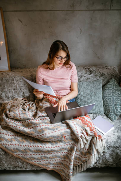istock Young student woman using laptop for studying while sitting in sofa 1441502707
