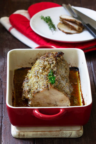 istock Pork loin baked with herbs, served in a baking dish. Rustic style. 1441503404