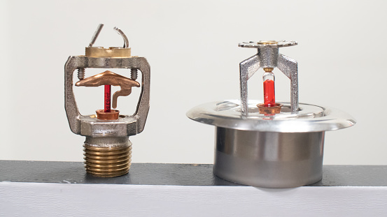 Fire suppression sprinkler heads with fusible links and frangible bulbs.